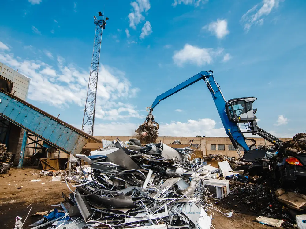 Materialumschlagbagger im Recyclingwerk, Restbid vermittelt Fahrzeuge und Maschinen weiter, bevor sie hier landen
